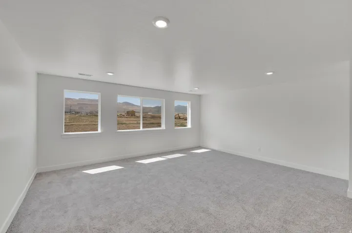 Spacious room with light gray carpet flooring and white painted walls