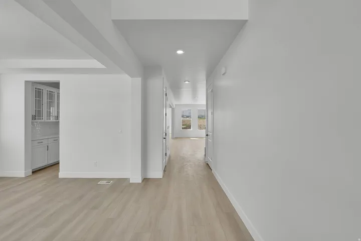 Light wood-finish flooring extends through the open concept layout, complemented by recessed lighting