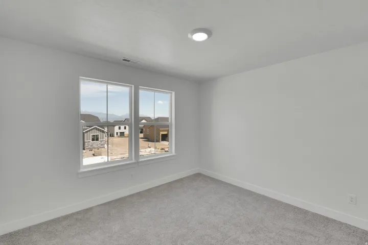 Room featuring neutral wall paint, gray carpet flooring, two large windows, white trim, and a recessed ceiling light fixture