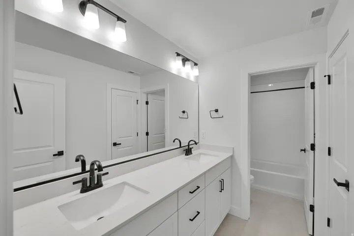 Dual vanity with white cabinetry and integrated sinks