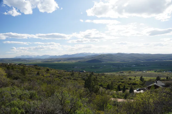 Expansive mountain and valley landscape featuring distant snow-capped peaks