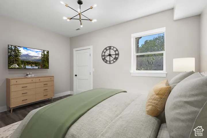 VIRTUALLY STAGED! Contemporary ceiling light fixture illuminating an interior space with a window, white trim, wood-finish flooring, and a three-panel interior door with dark hardware