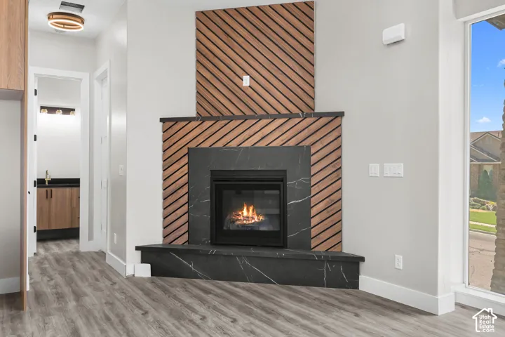 Contemporary fireplace featuring black-veined stone surround and hearth, accented by a diagonal wood-slat design
