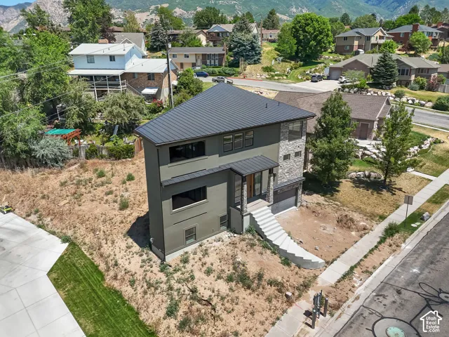 Contemporary two-story residence with a dark metal roof and stone veneer accents