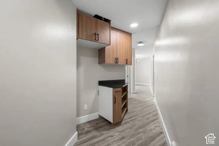 Hallway featuring built-in cabinetry with wood-finish doors and matte black hardware