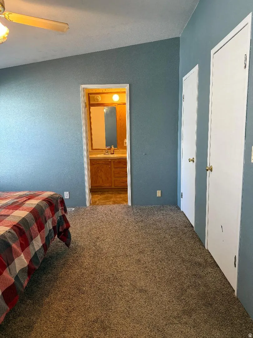 Master Bedroom Carpeted room with a vaulted ceiling and ceiling fan