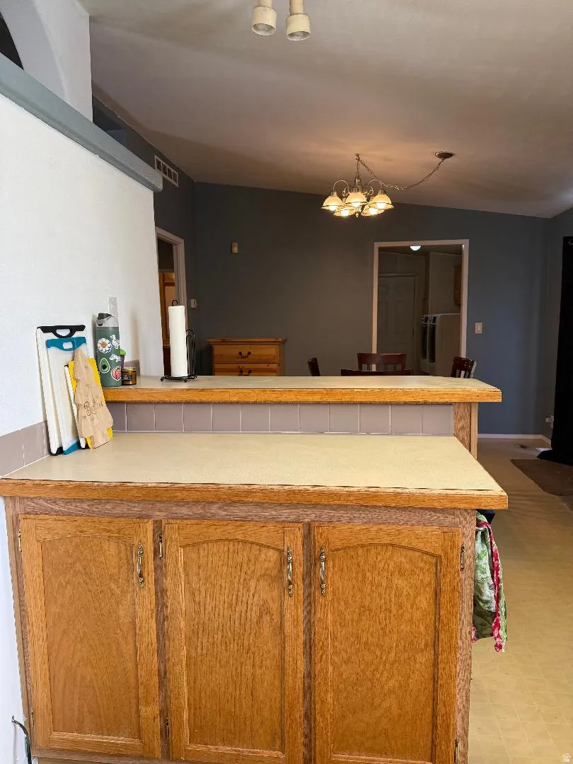 Oak wood cabinetry with matching wood-finish countertops and a tiled backsplash