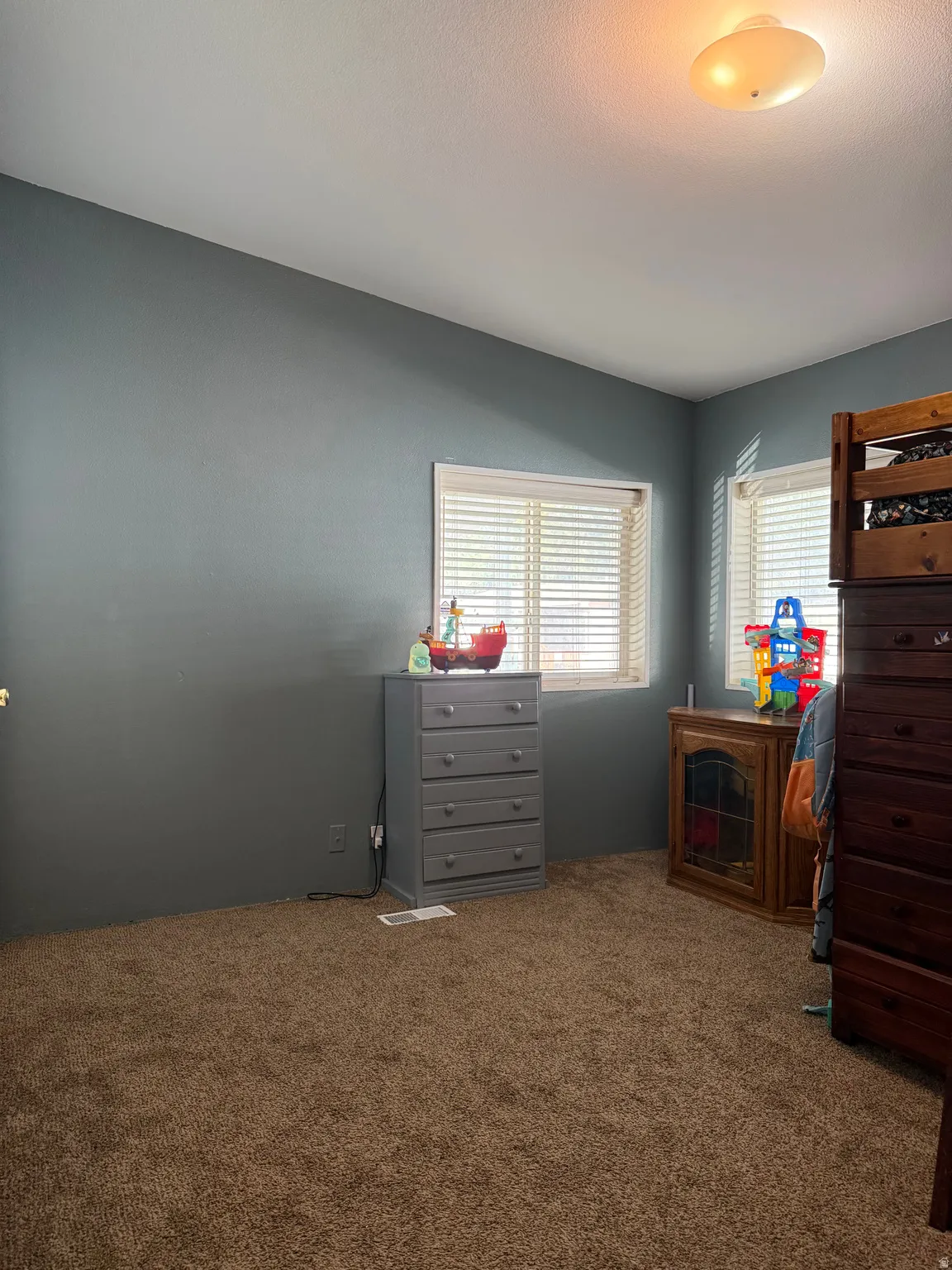 Large 2nd bedroomFeaturing two windows with blinds, gray painted walls, and brown carpet flooring