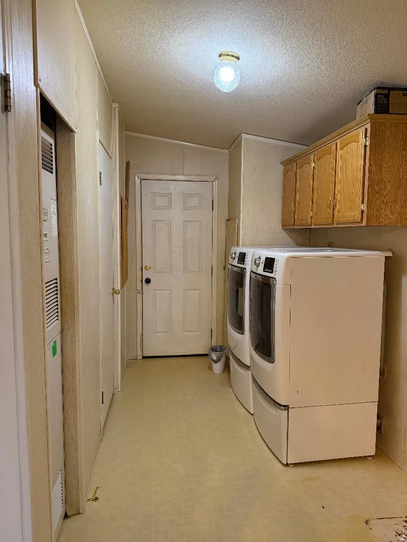 Utility space featuring built-in cabinetry, vinyl flooring, and a flush mount ceiling light
