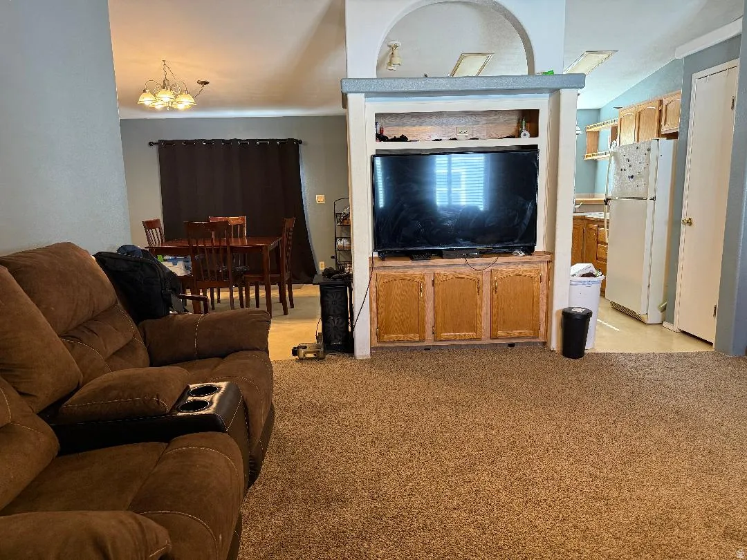 Living area featuring carpet flooring and a built-in entertainment center with wood-finish cabinetry
