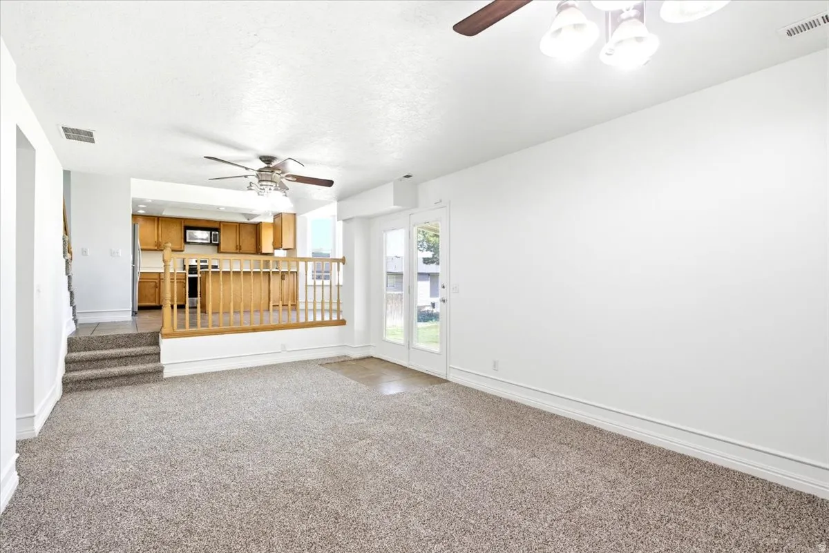 Open concept living space featuring carpet flooring and white painted walls