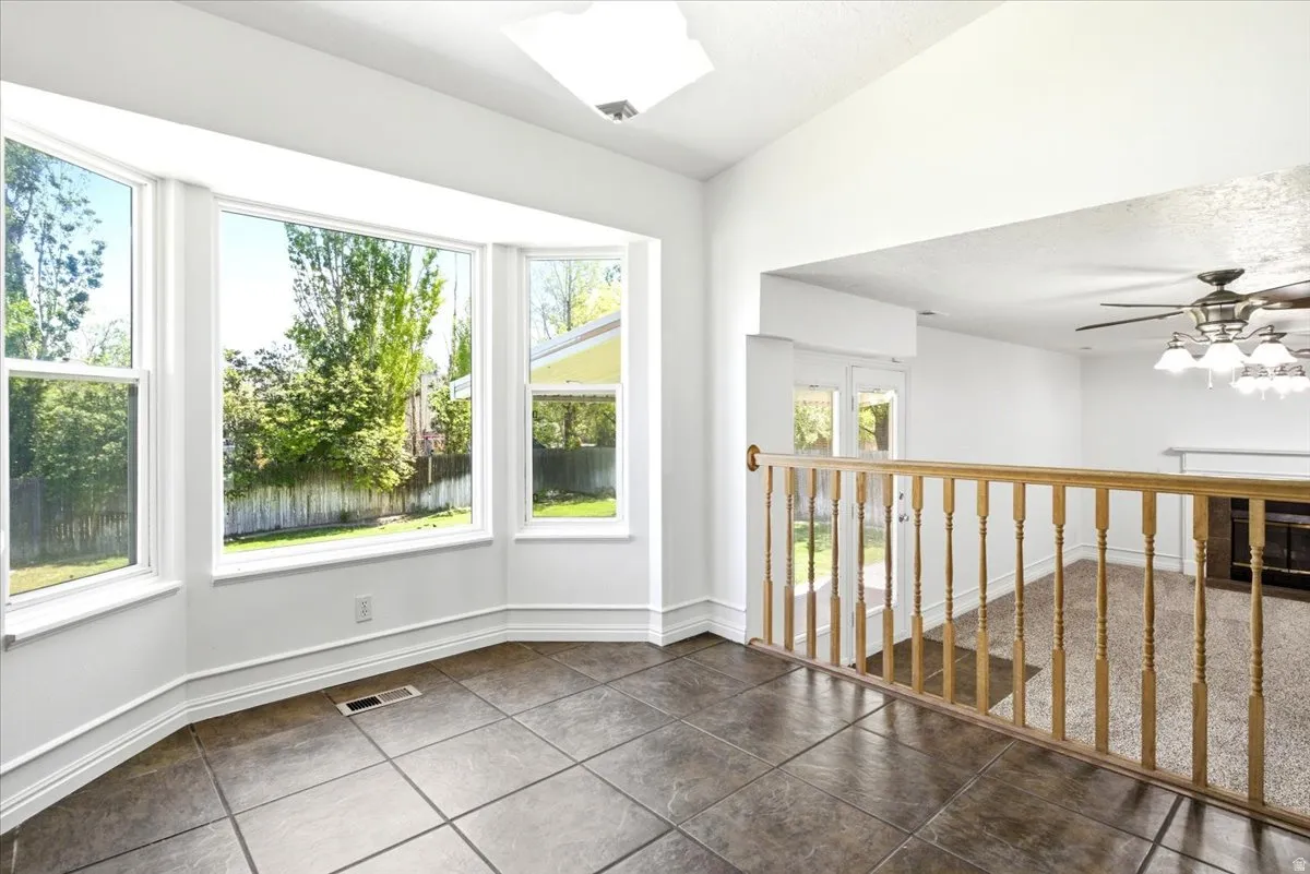 Bay window with multiple large windows, dark tile flooring, and white trim