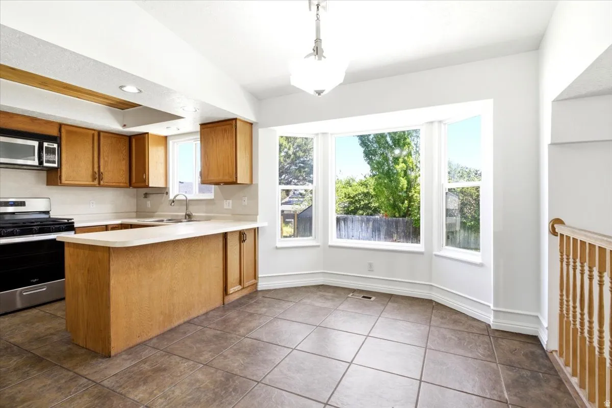 Kitchen featuring wood cabinetry, stainless steel appliances, and a light-toned countertop