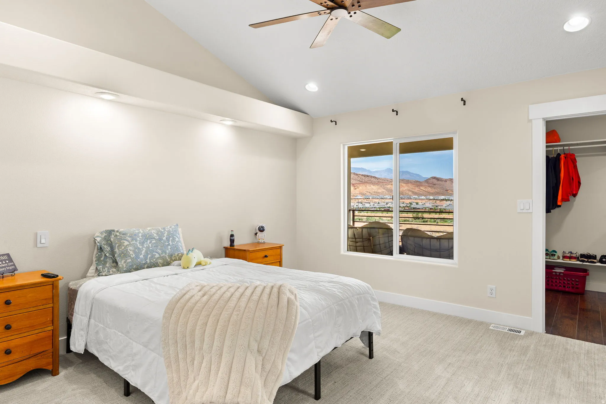 Room featuring a window with distant mountain scenery, vaulted ceiling, recessed lighting, and a ceiling fan