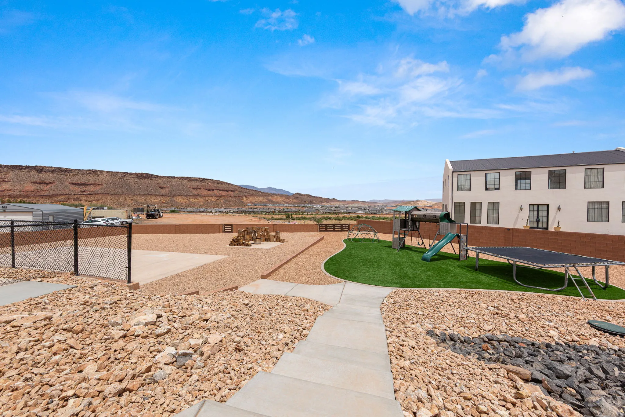 Expansive outdoor area featuring a manicured artificial turf section and a surrounding gravel landscape