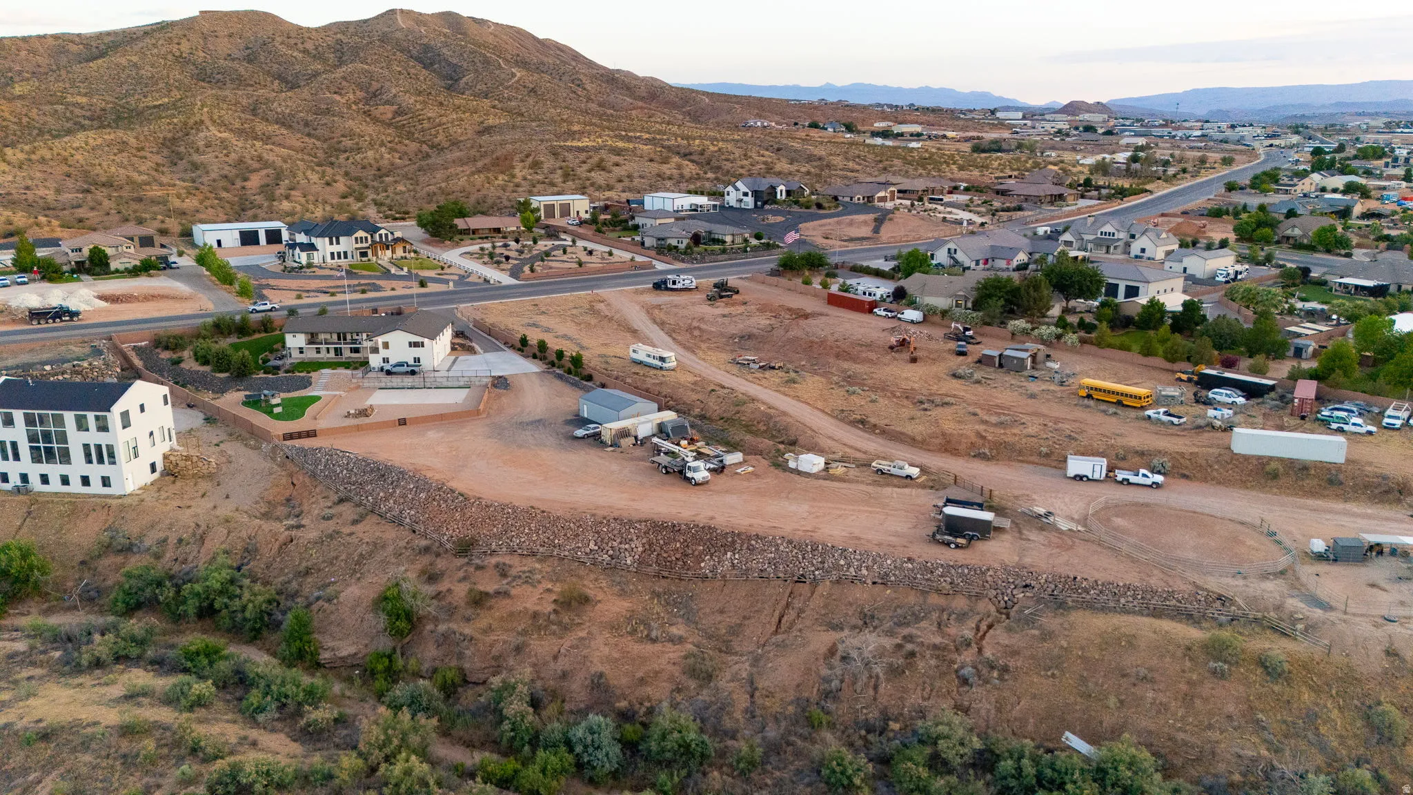 Expansive elevated parcel featuring a significant flat pad, existing hardscaping, and a retaining wall