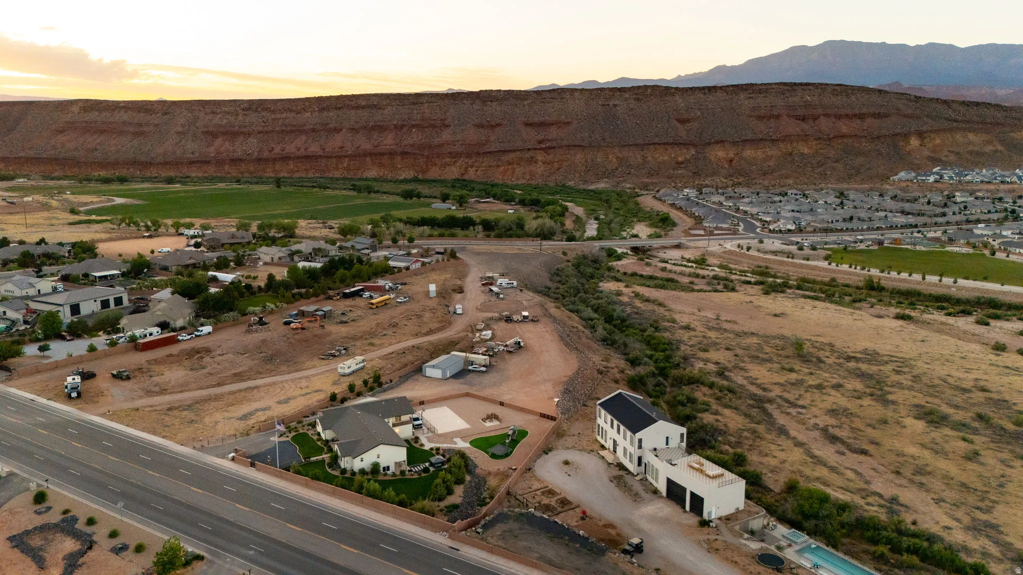 Aerial perspective showcasing a sprawling property with two distinct structures and a swimming pool