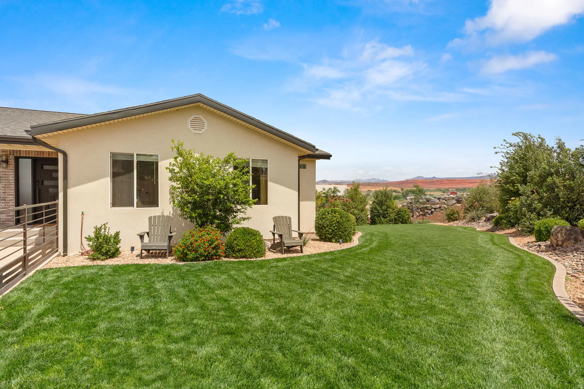 Spacious rear yard featuring an expansive lawn, mature landscaping, and a desert mountain backdrop