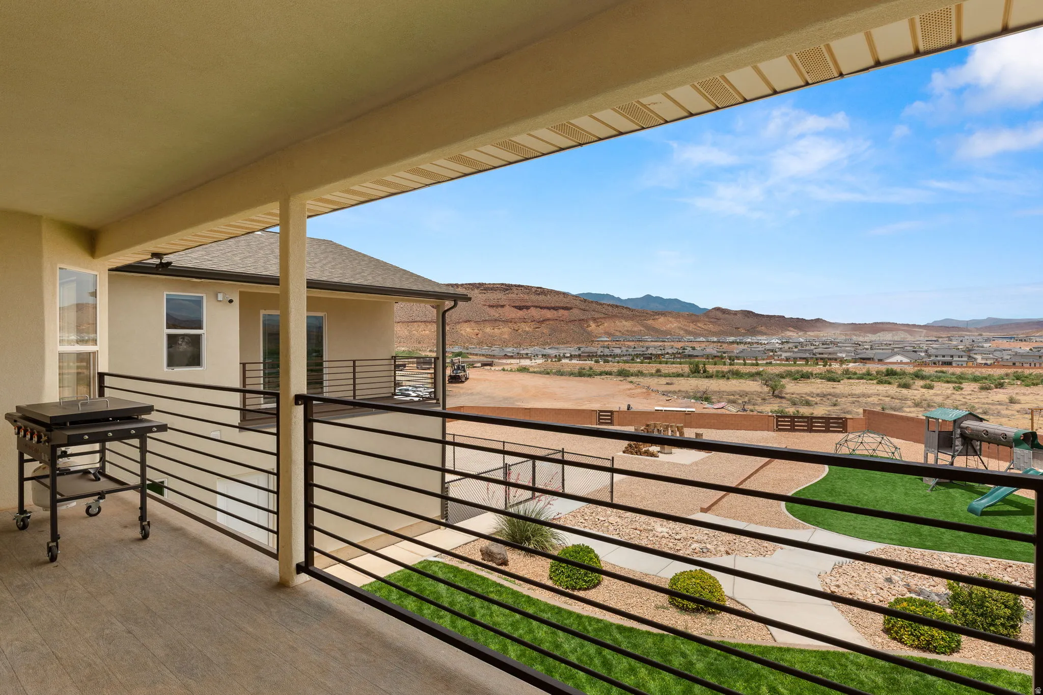 Covered outdoor living space featuring wood-finish flooring and black horizontal railings