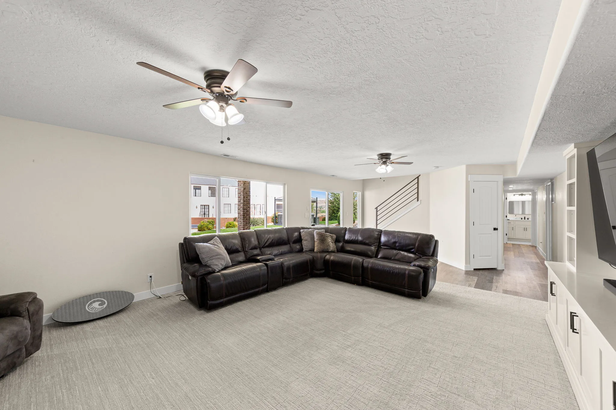 Spacious living area featuring light carpeting and neutral wall tones