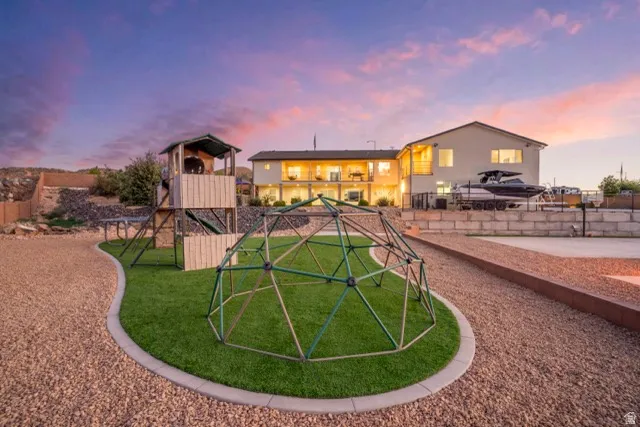 Expansive backyard featuring a manicured lawn area, gravel pathways, and a multi-level playset
