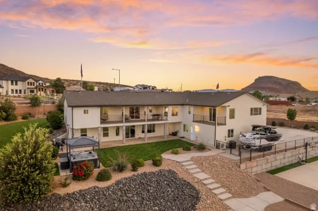Contemporary residence featuring an expansive rear yard, two upper-level balconies, and a lower-level covered patio