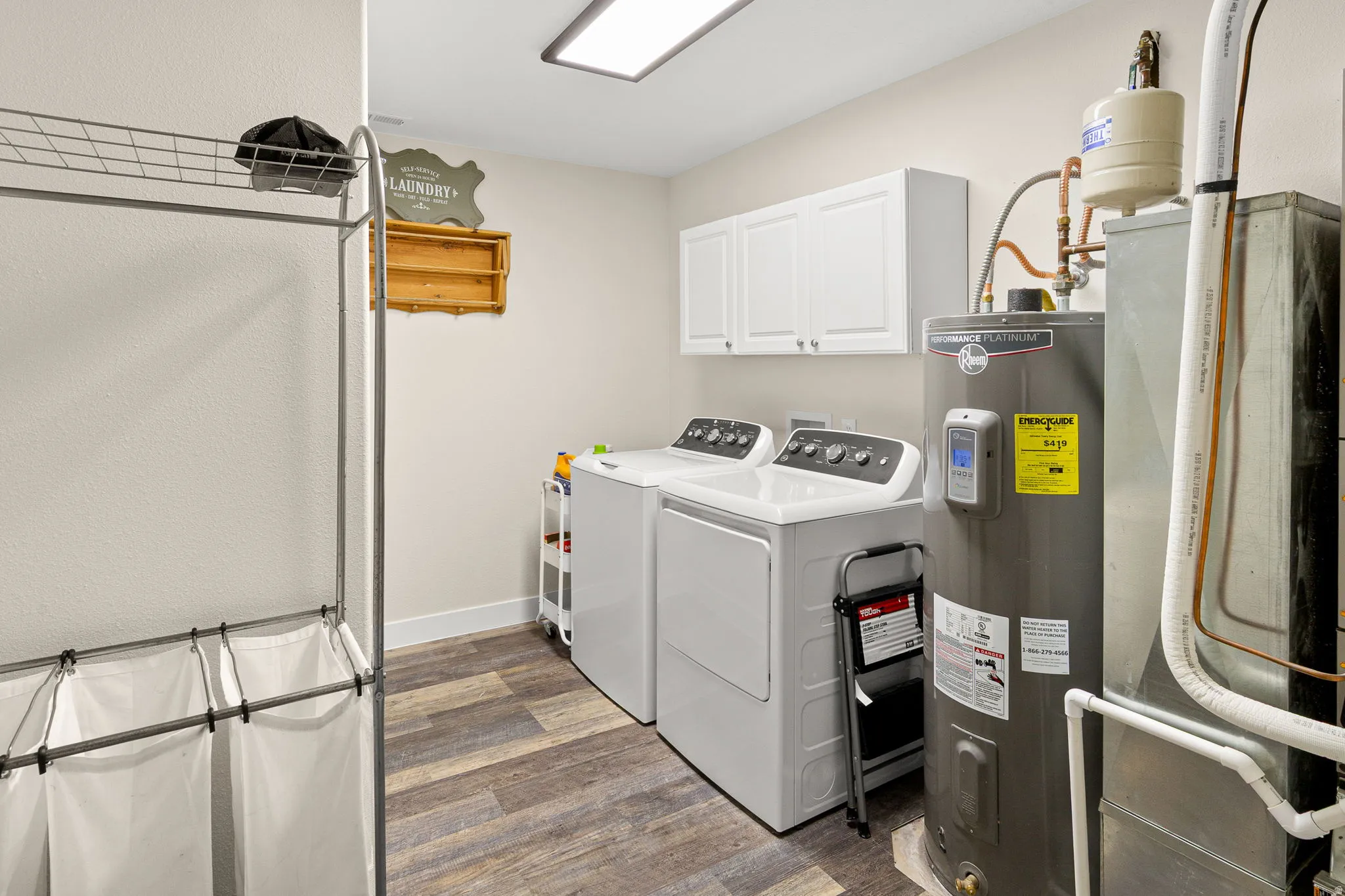 Dedicated utility space featuring wood-finish flooring and a ceiling-mounted light fixture
