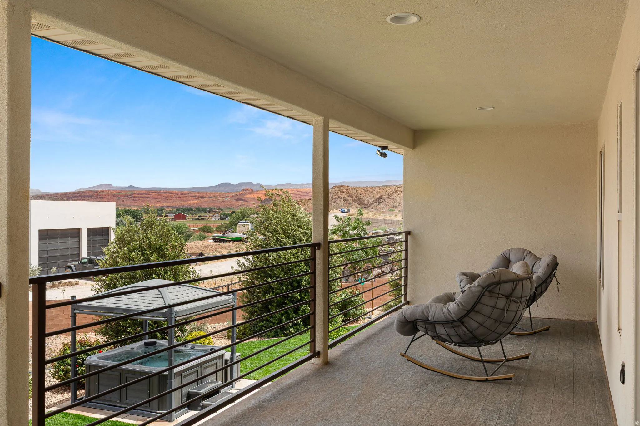 Covered balcony with tile flooring and a black metal railing