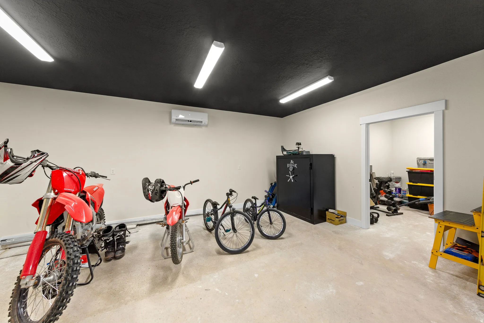 Spacious utility room featuring a black ceiling, light beige walls, and light-colored concrete flooring
