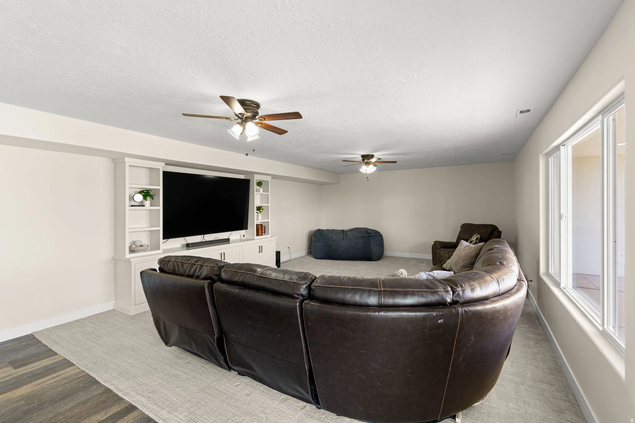 Entertainment space featuring built-in media cabinetry, recessed lighting, and ceiling fans