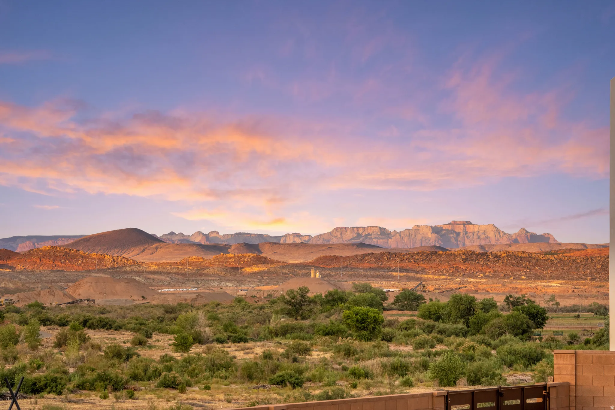 Expansive desert landscape with distant mountains under a vibrant sky