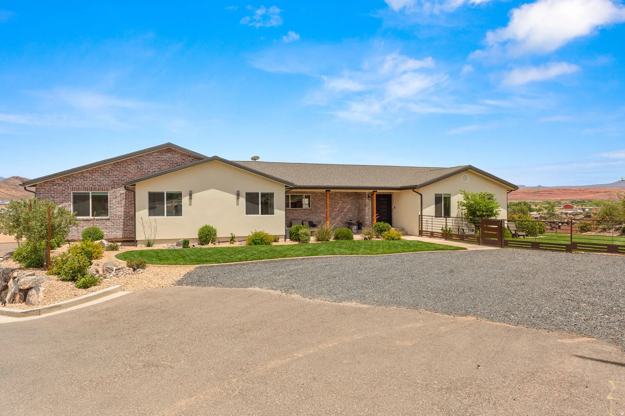 Contemporary residence featuring a brick and stucco exterior, a covered entryway, and a low-pitched roofline