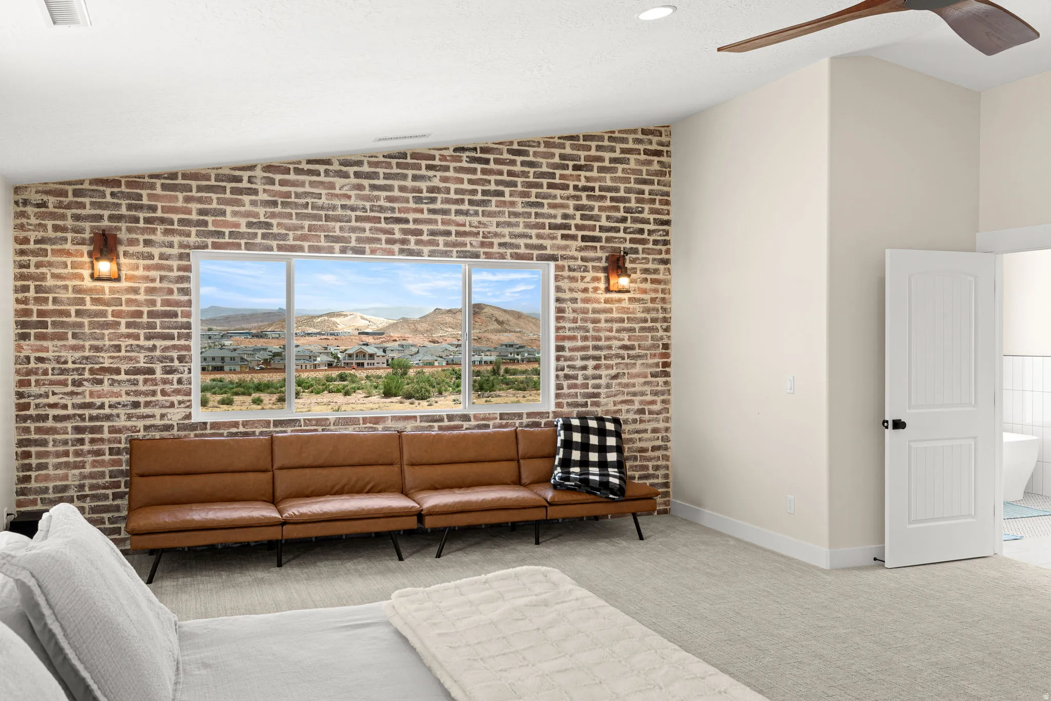 Exposed brick accent wall with three large windows