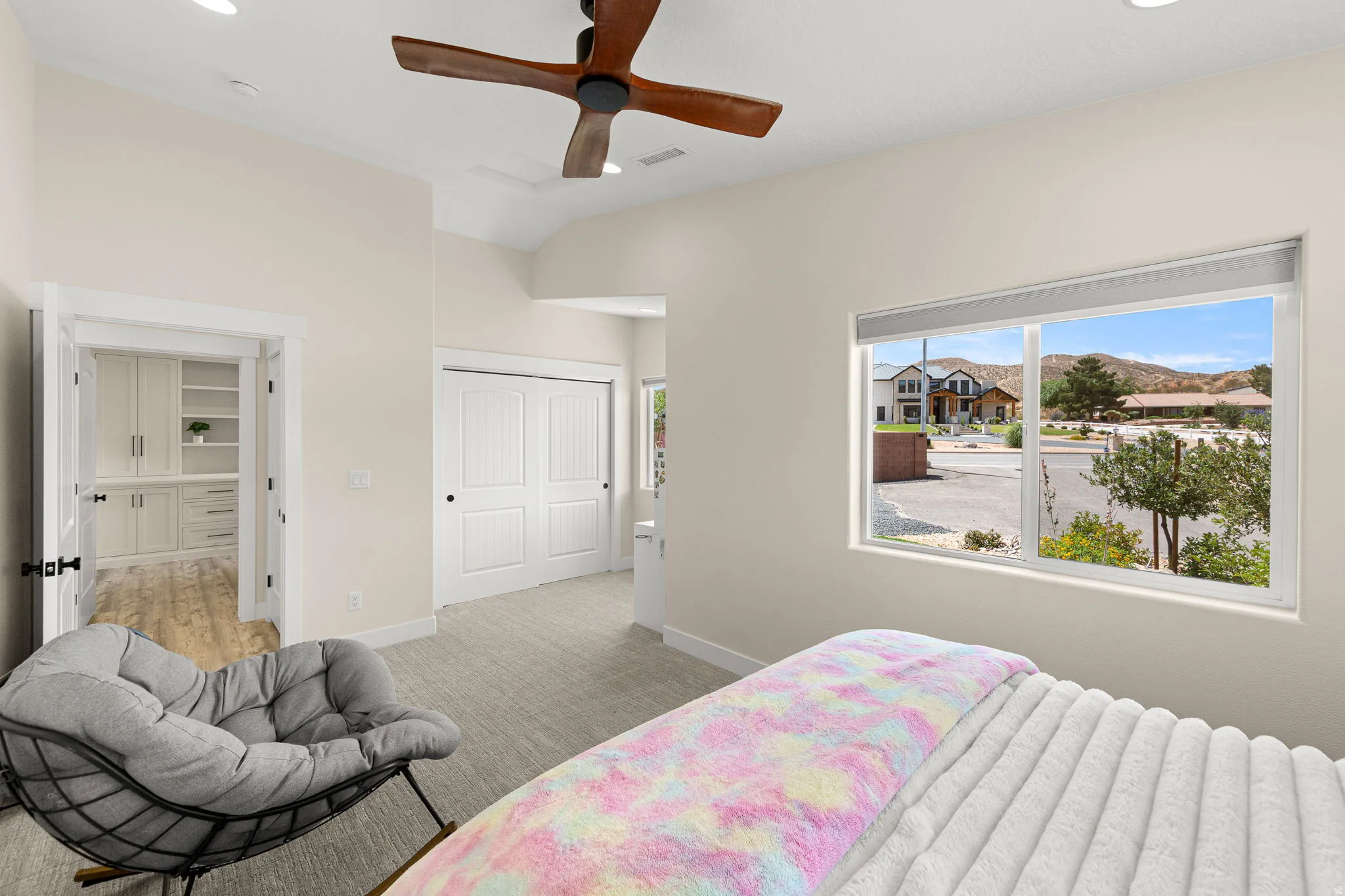 Spacious interior room featuring a large window, vaulted ceilings, and recessed lighting