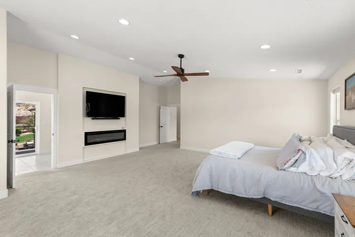 Spacious room featuring vaulted ceilings, recessed lighting, a built-in electric fireplace, and light-toned carpeting