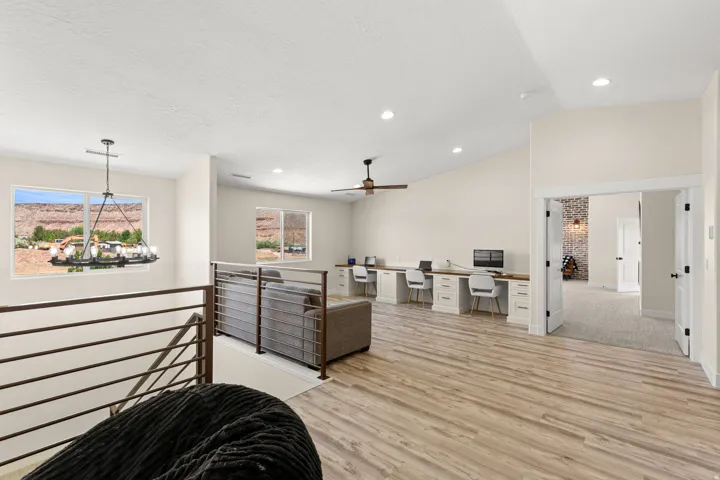 Spacious loft area featuring wood-finish flooring, vaulted ceilings, and recessed lighting
