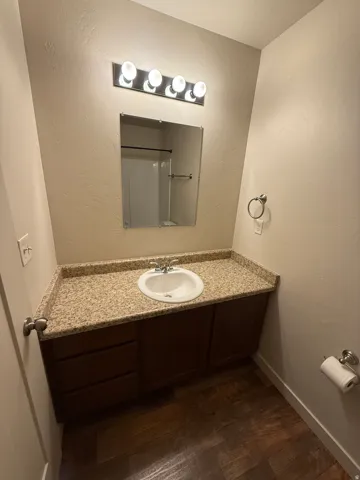 756-Bathroom vanity featuring a speckled countertop, integrated sink, and dark wood-finish cabinetry