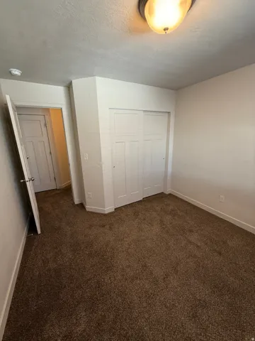 S756-pacious room featuring brown carpeting, white baseboards, and a ceiling-mounted light fixture
