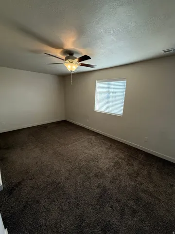 756-Spacious room featuring dark pile carpeting, neutral wall finishes, and a single window with blinds