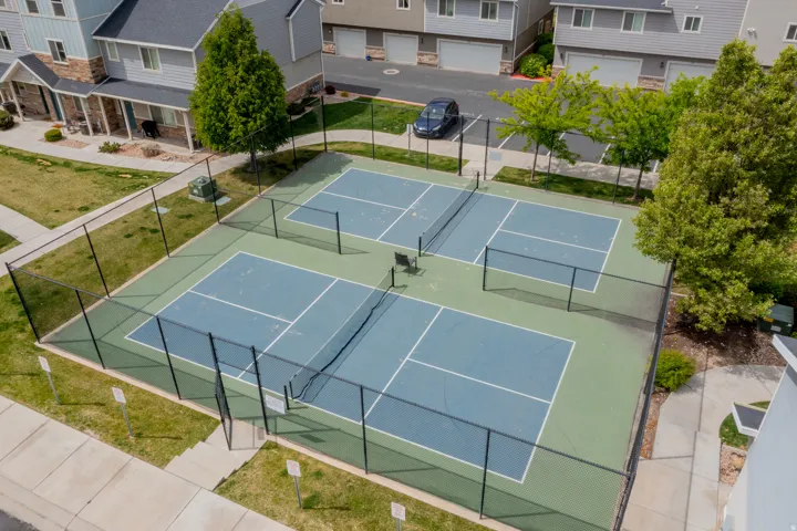 Fenced pickleball courts featuring a hardcourt surface with painted lines and nets