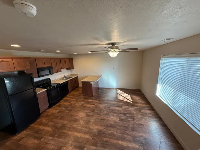 756-Open-concept kitchen and living area featuring wood-finish flooring, recessed lighting, and a ceiling fan