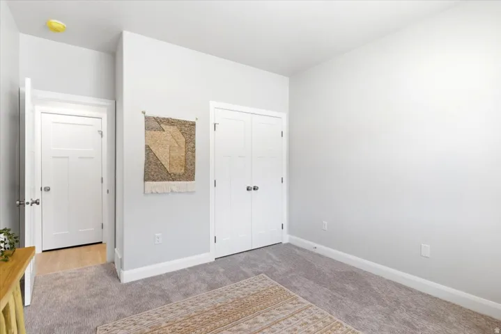 Neutral-toned room featuring light gray walls, plush gray carpeting, and white trim