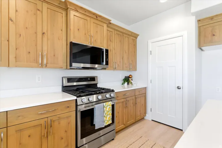 Light wood-finish cabinetry complemented by white countertops