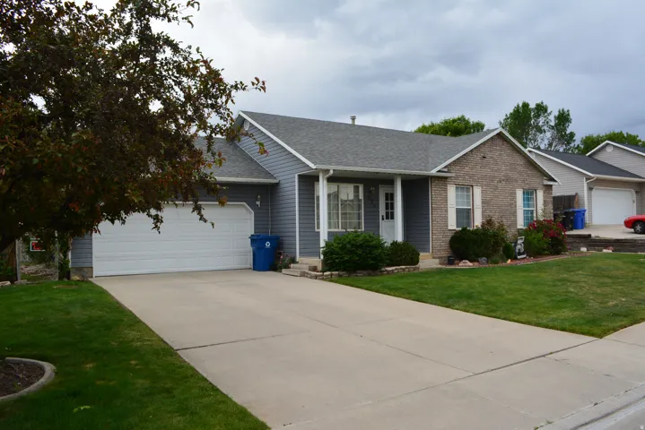 Ranch-style residence featuring a combination of brick and siding, an attached two-car garage, a covered front porch, and a concrete driveway