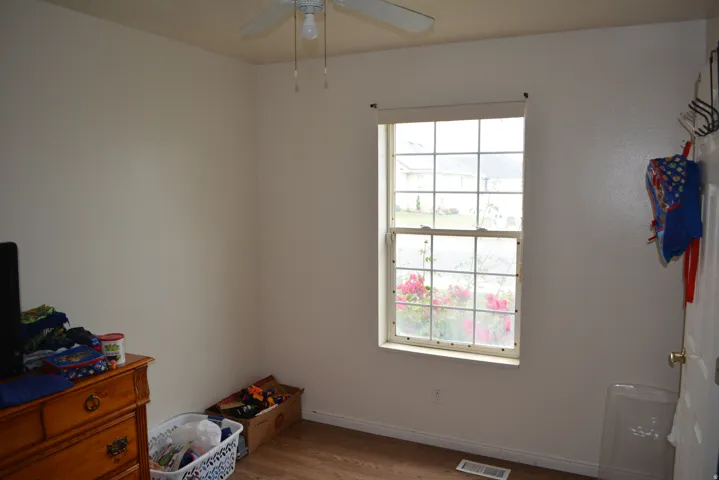 Room featuring a single-hung window with a ceiling fan, and neutral painted walls