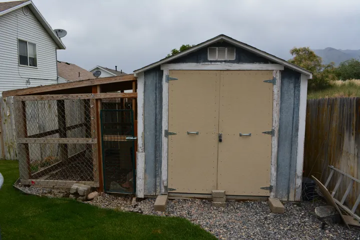 Outdoor storage shed featuring double doors and a gabled roof