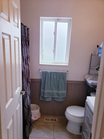 Bathroom with beadboard wainscoting, tile flooring