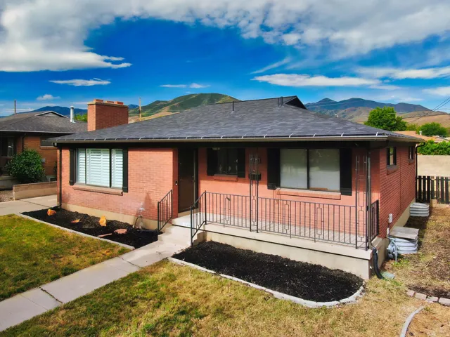 Brick exterior featuring a dark asphalt shingle roof