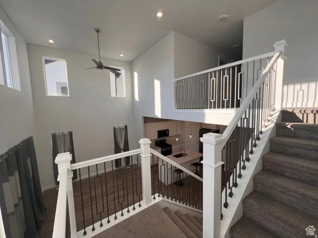 Two-story living area with high ceilings, recessed lighting, and a contemporary ceiling fan