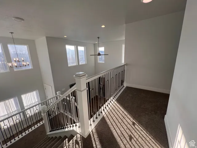 Upper landing featuring carpeted flooring and white walls